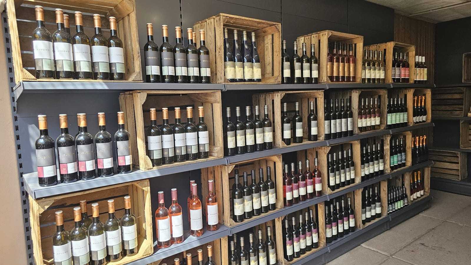 Weinregal aus Holzkisten mit Rot- und Roséweinen im Verkaufsraum