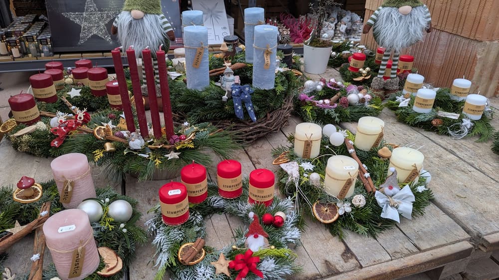Fertige Adventsgestecke mit Kerzen auf einem Tisch